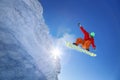 Snowboarder jumping against blue sky