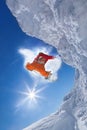 Snowboarder jumping against blue sky