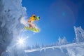 Snowboarder jumping against sunset