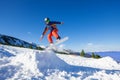 Snowboarder jumping high from hill in winter