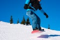 Snowboarder Jumping over Slope on Red Snowboard in the Mountains at Sunny Day. Extreme Snowboarding and Winter Sports Royalty Free Stock Photo