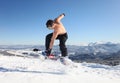 Snowboarder jumps up on the mountain top