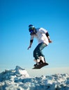 Snowboarder making jump against the blue sky Royalty Free Stock Photo