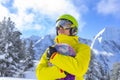 Snowboarder man with ski glasses in green helmet make photoshoot on top in Alps mountains. On the background of Royalty Free Stock Photo