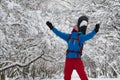 Snowboarder, with open arms, is delighted in the winter forest