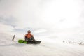 Snowboarder sitting on snow in Goderdzi, Georgia