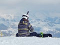 A snowboarder is preparing for the ride.