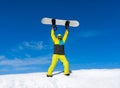 Snowboarder raised hands arms up hold snowboard on