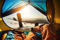 Snowboarder relaxing in tent on background of sunset