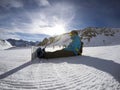 Snowboarder resting on the slope - winter sports scene. Beautiful mountain view