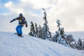 Snowboarder rides down, arms outstretched