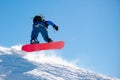 Snowboarder Riding Red Snowboard in Mountains at Sunny Day. Snowboarding and Winter Sports Royalty Free Stock Photo