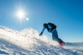 Snowboarder Riding Red Snowboard in Mountains at Sunny Day. Snowboarding and Winter Sports Royalty Free Stock Photo