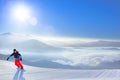 Snowboarder Riding Red Snowboard on the Slope in the Mountains in Bright Sun. Snowboarding and Winter Sports