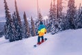 Snowboarder riding on slope with snowy forest, sheregesh ski resort sunset. Concept freeride extreme sport Royalty Free Stock Photo