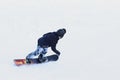 Snowboarder riding on a snowboard down the snow-covered slope at a ski resort. Winter sport. Freestyle and slalom descent.