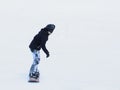 Snowboarder riding on a snowboard down the snow-covered slope at a ski resort. Winter sport. Freestyle and slalom descent.