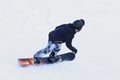 Snowboarder riding on a snowboard down the snow-covered slope at a ski resort. Winter sport. Freestyle and slalom descent.