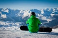 Snowboarder seated looking the mountains Royalty Free Stock Photo