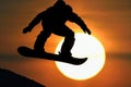 snowboarder silhouette against the setting sun during a jump