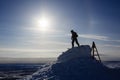 Snowboarder silhouette in sunlight on mountain top ready for descent