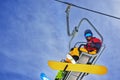 Snowboarder sitting on chairlift and smiling, close-up