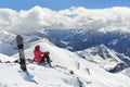 Snowboarder sitting on edge of the mountain