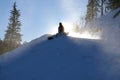 Snowboarder sitting in front of the sun