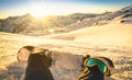 Snowboarder sitting on relax moment at sunset in ski resort