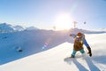 A snowboarder in a ski mask and a backpack is riding on a snow-covered slope leaving behind a snow powder against the Royalty Free Stock Photo