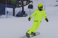 Snowboarder skiing in bright yellow suit, overalls