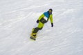 Snowboarder slides down a slope against the background of snow