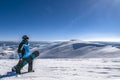 Snowboarder with snowboard in hand on mountain top. Winter freeride snowboarding