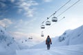 Snowboarder stands ready beneath a cable road, ready for the slopes