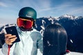 Snowboarder use smatphone on winter mountain top Royalty Free Stock Photo