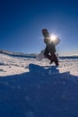 Snowboarder walking against blue sky