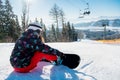 Snowboarder woman resting on ski slope under the lift Royalty Free Stock Photo