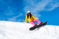Snowboarder woman sitting on snow mountain slope Royalty Free Stock Photo