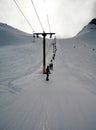 Snowboarders rise on a lift in the mountain