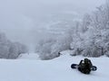 Snowboarders sitting on the trail looking down to beautiful panorama valley