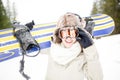 Snowboarding.Young beautiful woman with ski mask holding her snowboard at ski slope Young woman in ski resort Royalty Free Stock Photo