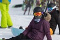 A Snowbord sitting on the snow in a purple jacket and reflective glasses. Mountain holiday concept, sport. Sunny day. Val di Fiemm Royalty Free Stock Photo