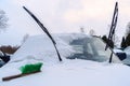 On the snowbound car hood lies a green brush.