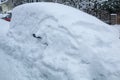 Snowbound car in the street, buried under a big snow layer