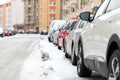 Snowbound cars parked at the roadside