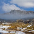 snowbound mountain valley in dense mist and clouds