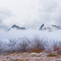 snowbound mountain valley in dense mist and clouds