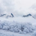 snowbound mountain valley in dense mist and clouds