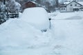 Snowbound car in the street after an onset of winter