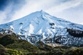 Snowcapped peak of magnificent Mount Taranaki in fading daylight